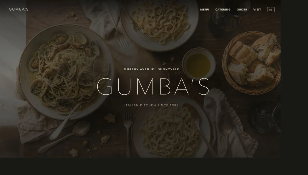 Portada del sitio de Gumba's: fotografia cenital de pasta sobre mesa de madera con el nombre del restaurante encima