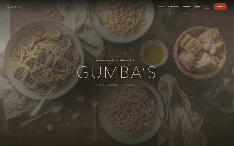 Portada del sitio de Gumba's: fotografia cenital de pasta sobre mesa de madera con el nombre del restaurante encima